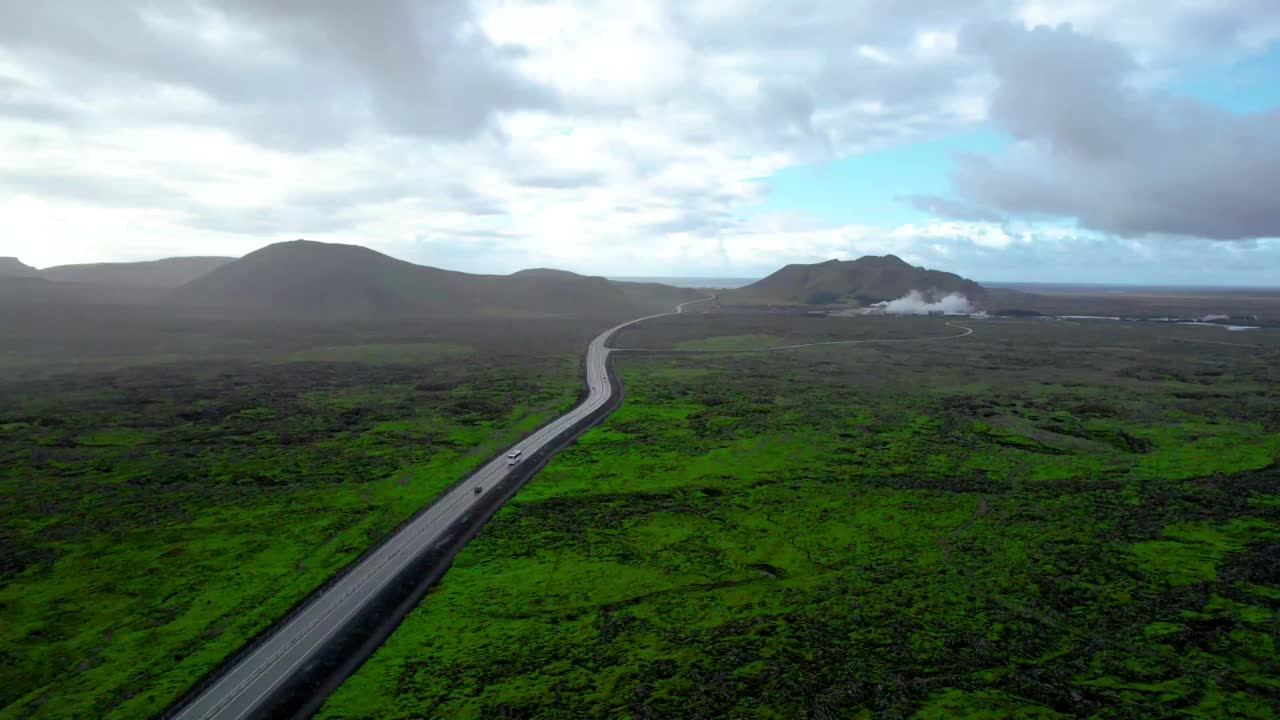 航拍的笔直的道路与冰岛的熔岩平原景观。视频素材