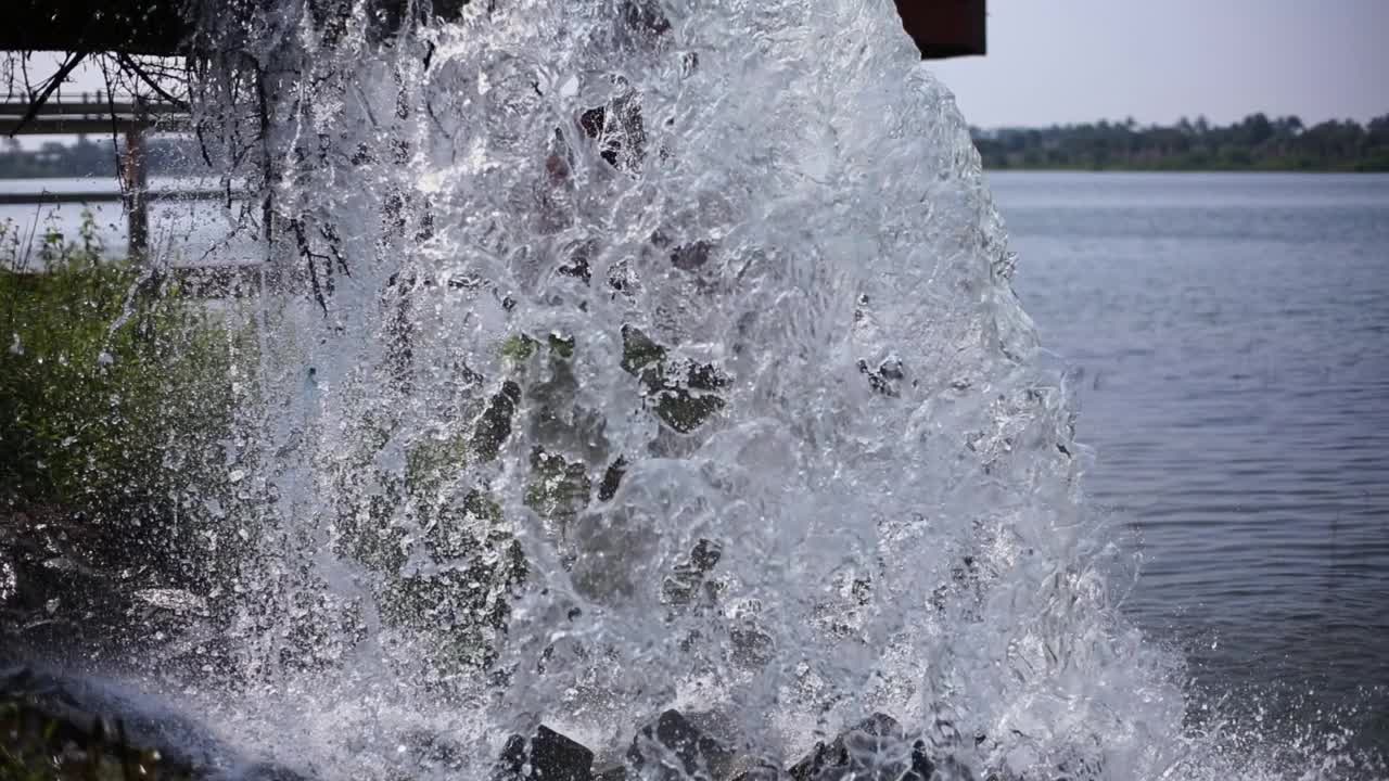 大量的水从那根大金属管涌到湖里视频素材