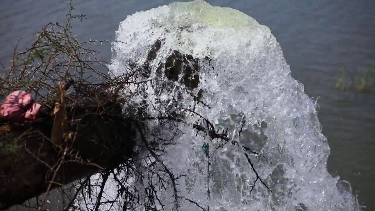 大量的水从那根大金属管涌到湖里视频素材