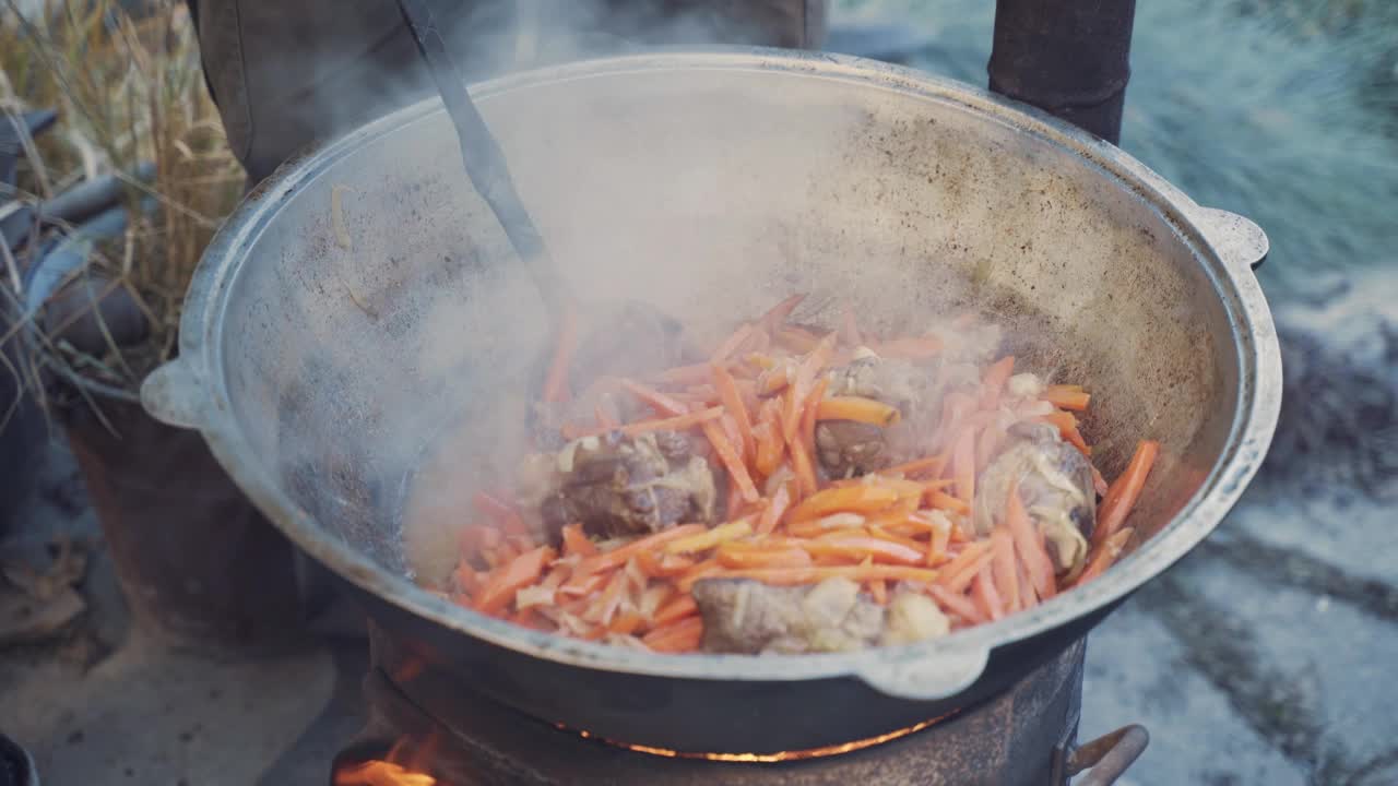 男人用漏勺混合肉、蔬菜和肉汤。视频素材