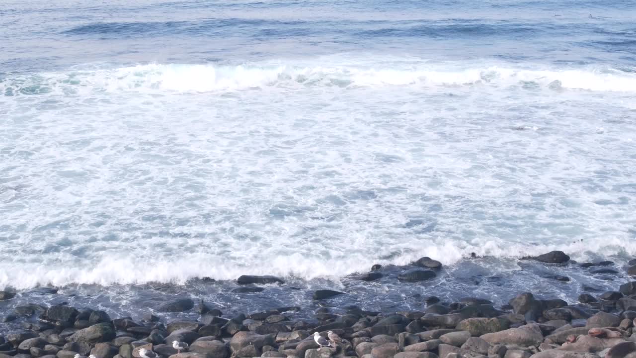 海浪拍打着海滩，海水表面。海岸上的卵石或石头视频素材