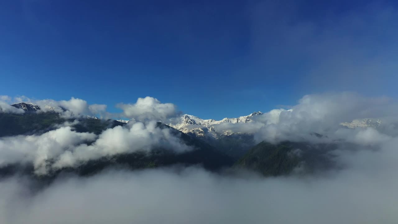 清晨云雾覆盖的雪山鸟瞰图。视频素材