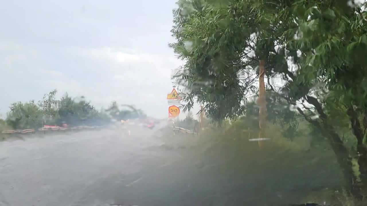 停在路边的一辆汽车透过挡风玻璃拍摄了倾盆大雨的视频。视频素材