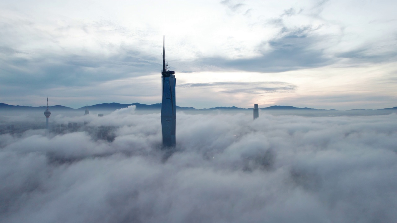 电影无人机镜头的城市与低云周围的摩天大楼在日出。视频下载