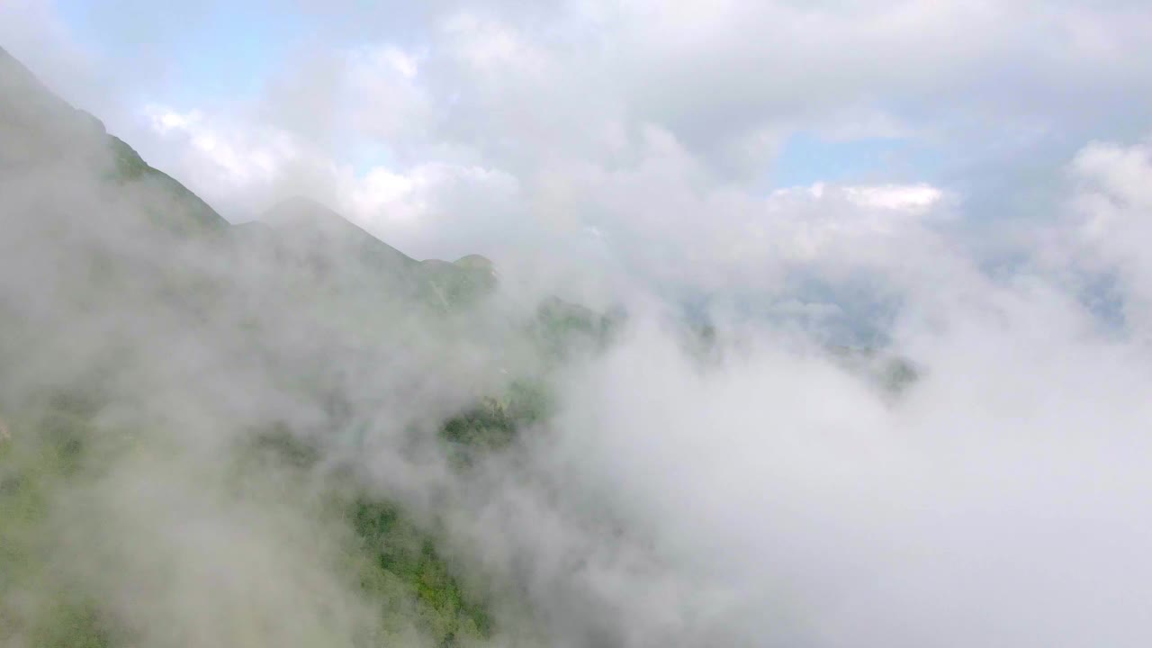 飞越云层中的高山，无人机正好飞向云层视频素材