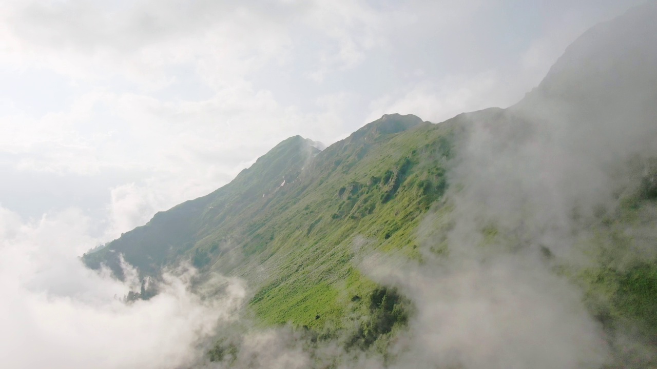 鸟瞰令人惊叹的山景。在日落时穿过云层。视频素材