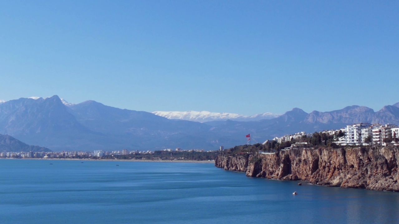 海景全景与岩石海岸上的大城市和遥远的山脉视频素材