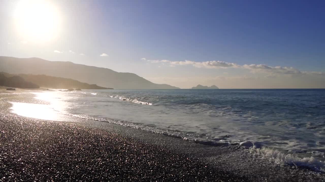 宁静的海景，多山的海岸和被清晨的阳光照亮的平静的海浪视频素材