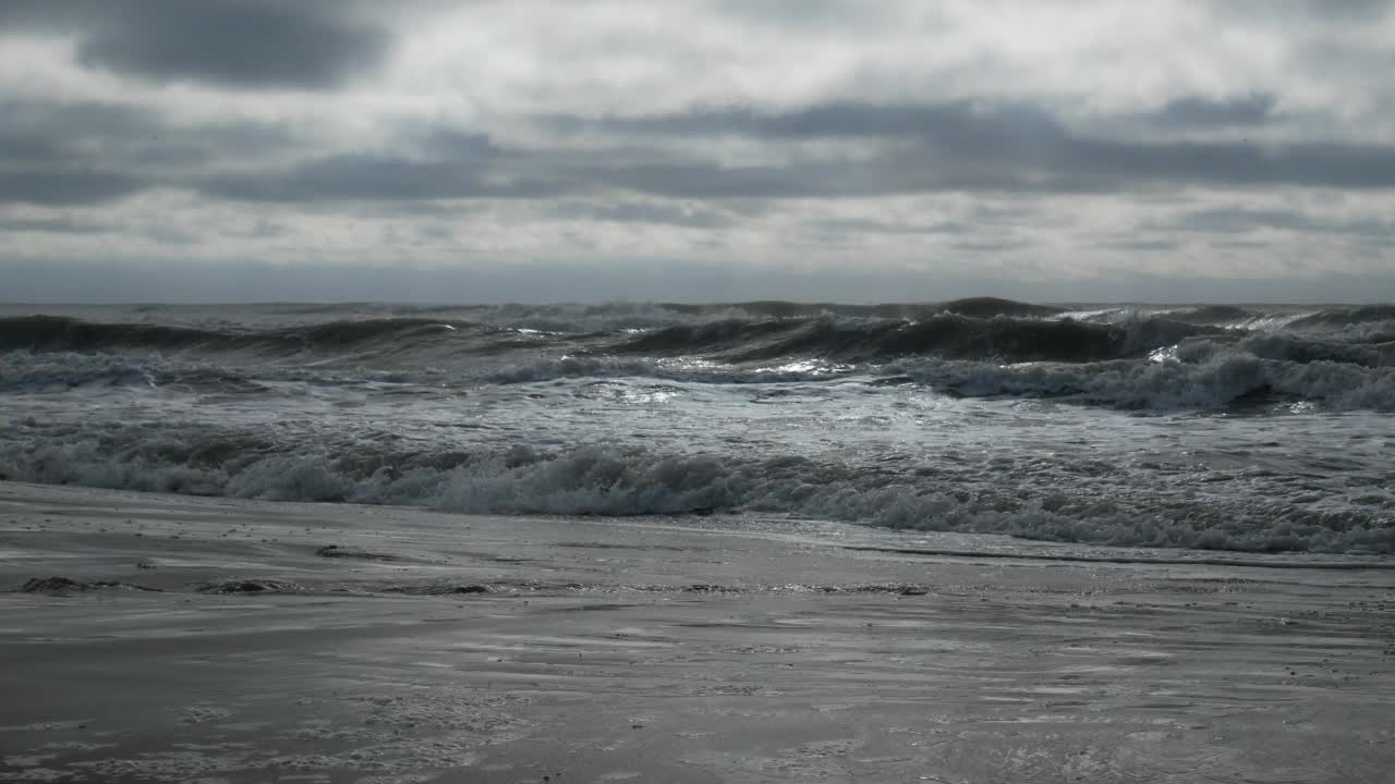 在多云的日子里，波涛汹涌的海面伴随着汹涌的海浪冲击着海岸线视频素材