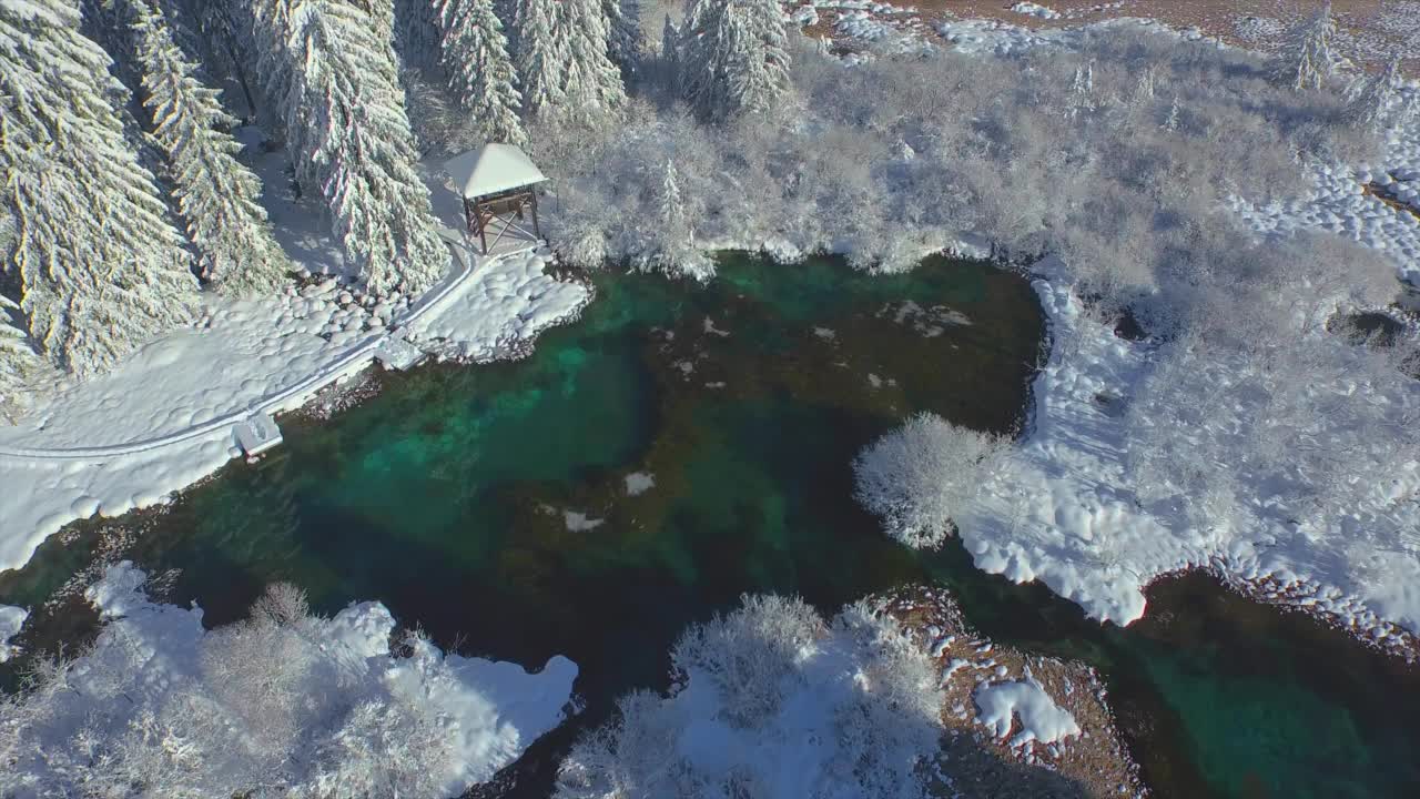 航拍:泽伦奇泉清澈的绿色的水在一个美丽的雪天冬天视频素材