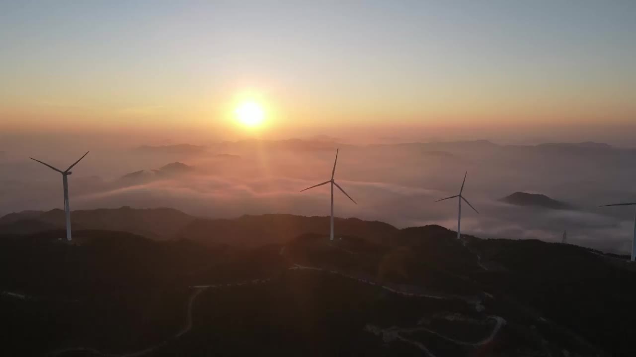 日出时的云海和山峰上的风车视频素材