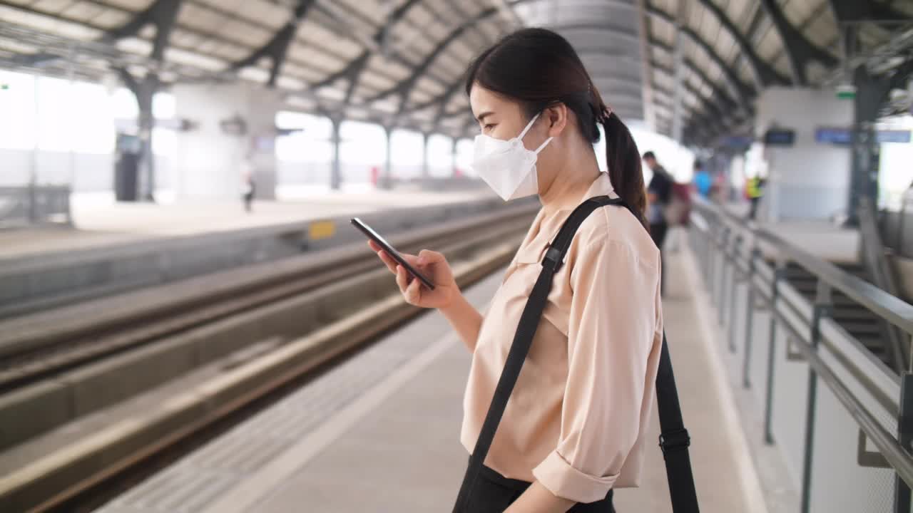 一名女子在曼谷车站用智能手机等火车视频素材