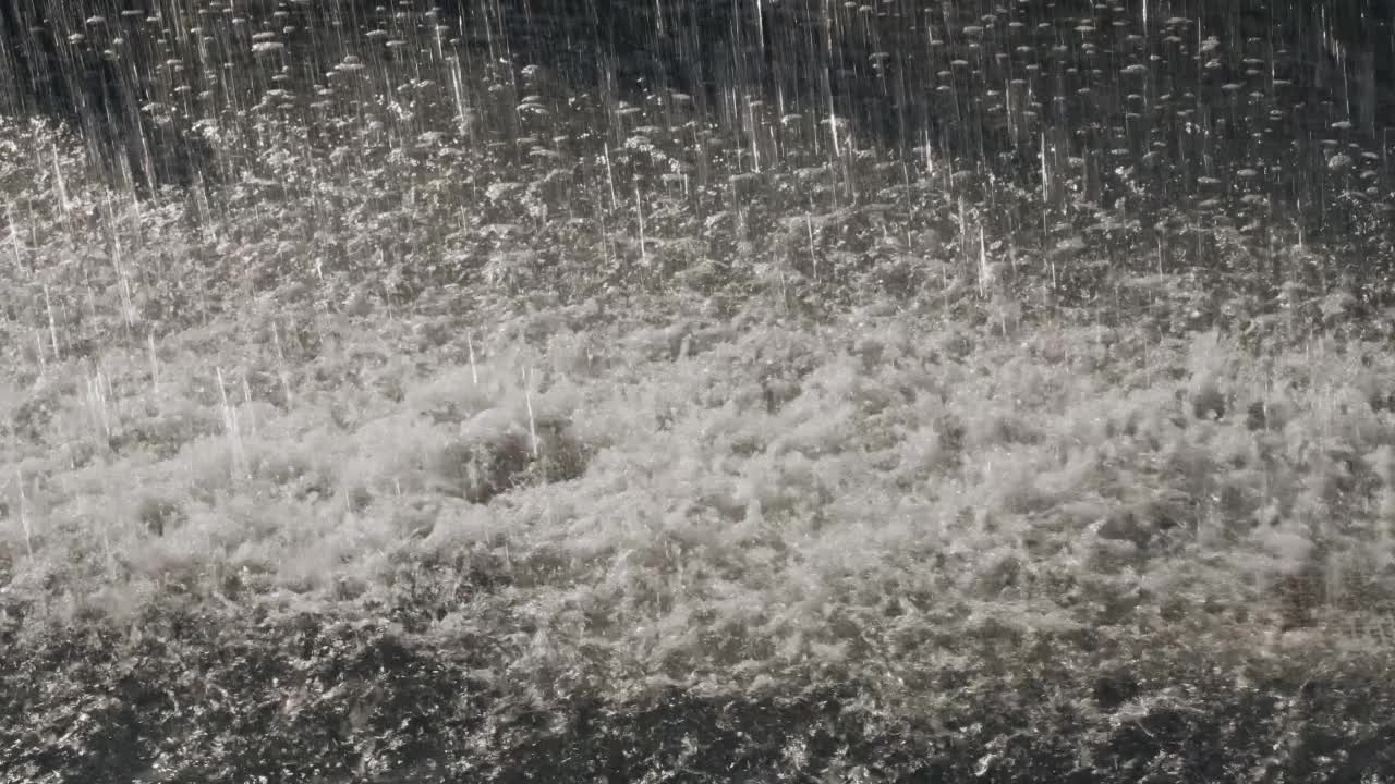 大滴大滴的雨落在水坑里。下大雨,倾盆大雨。视频素材