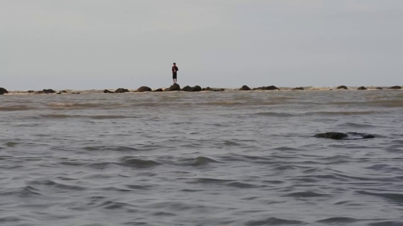 印度尼西亚中爪哇岛伦邦kartini海滩上的海浪。高清视频。海股票。看起来像远处的渔夫。视频下载