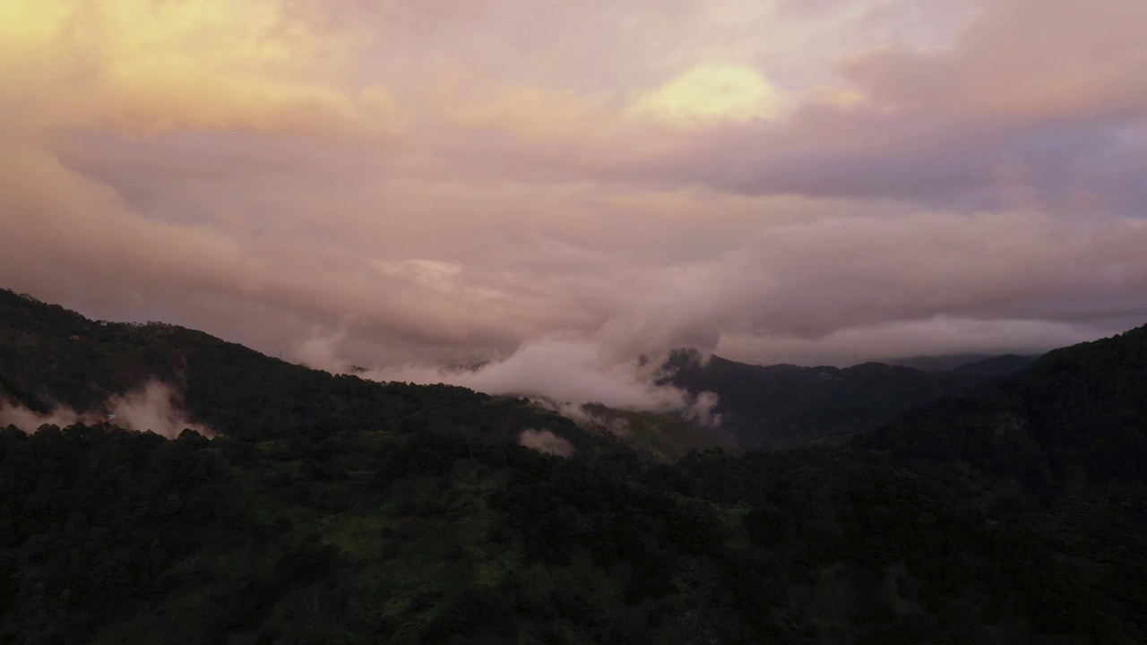 夕阳西下时，山峰耸立在云中。视频素材