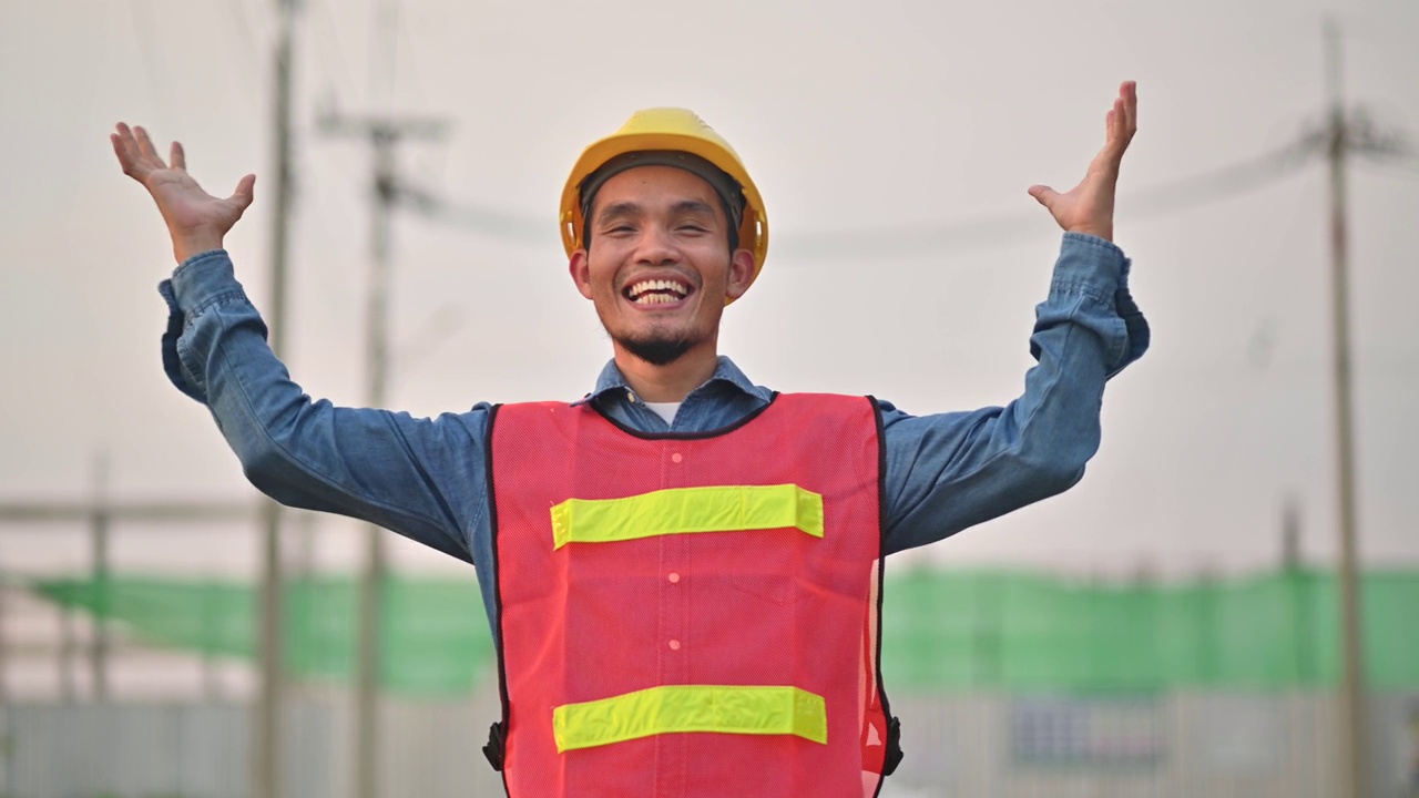 亚洲工程师勘察工地建筑工程，亚洲工人微笑着参加土建工地施工，安全服安全帽视频下载