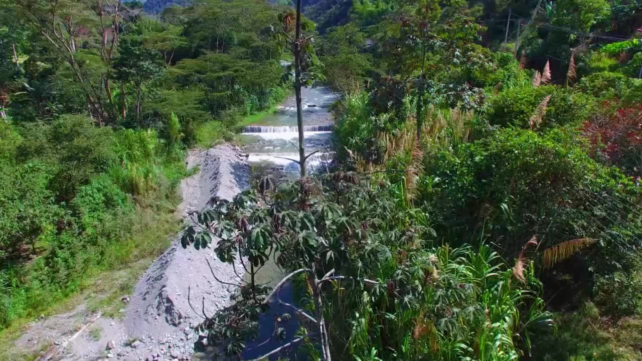 无人机拍摄的河流与强大的水流和岩石周围的树木在哥伦比亚和自然选择性焦点无噪声视频素材