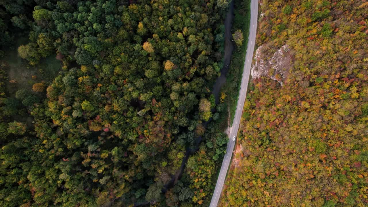 一条穿过峡谷的高速公路，峡谷上画满了秋色视频素材