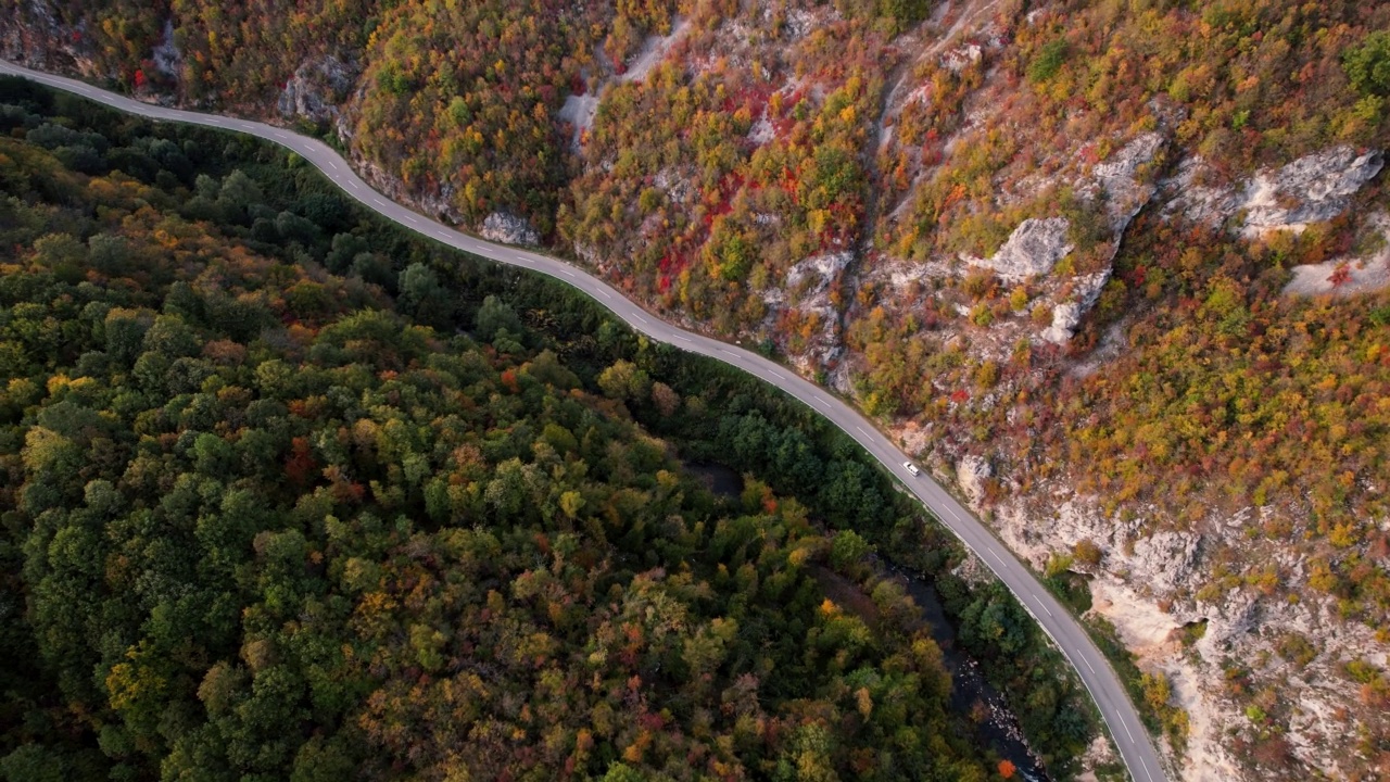 一条穿过峡谷的高速公路，峡谷上画满了秋色视频素材