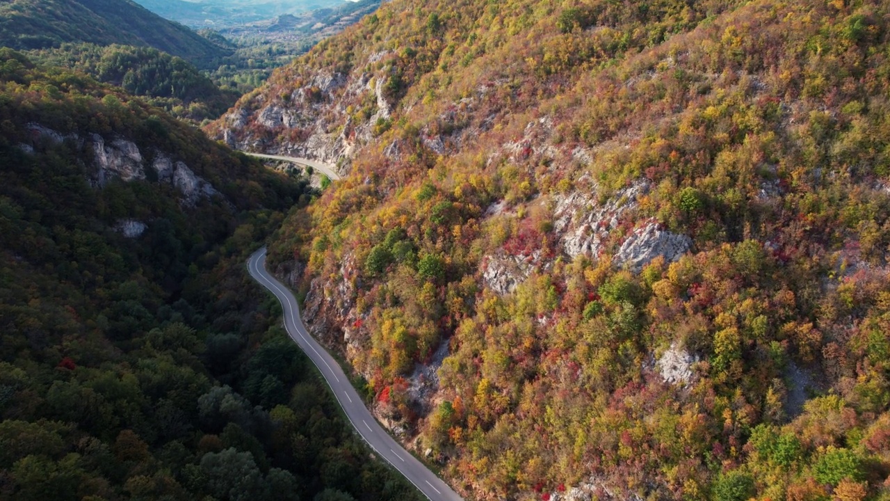 一条穿过峡谷的高速公路，峡谷上画满了秋色视频素材