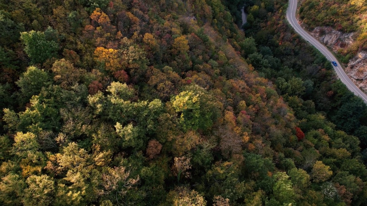 一条穿过峡谷的高速公路，峡谷上画满了秋色视频素材