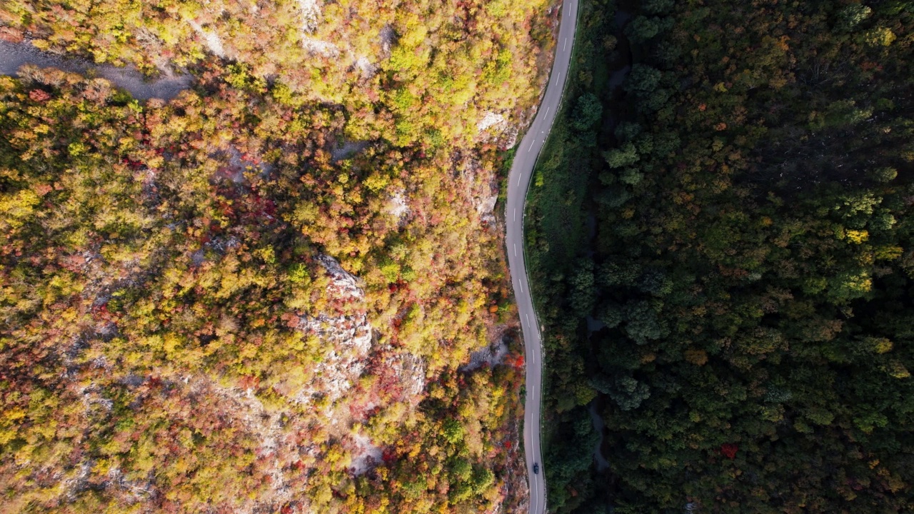 一条穿过峡谷的高速公路，峡谷上画满了秋色视频素材