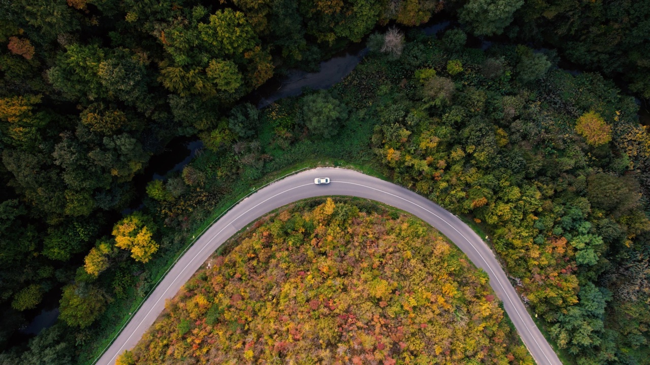 一条穿过峡谷的高速公路，峡谷上画满了秋色视频素材