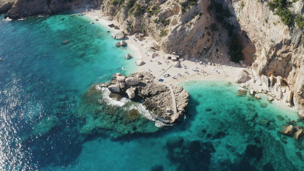 俯瞰绿松石海水和石墩的海滩。意大利撒丁岛，无人机拍摄。夏天海景视频素材