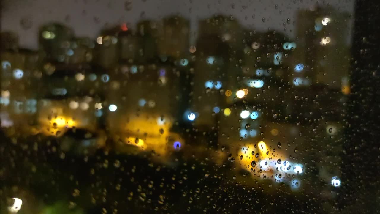 雨点打在夜晚的窗户上视频素材