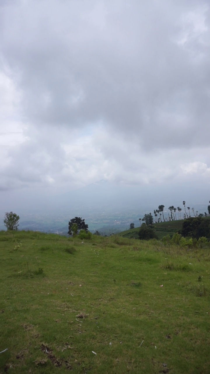 美丽的垂直自然风景山自然全景丘陵，森林的高绿树和山坡的绿色种植园在多云的蓝天下，在白天视频素材