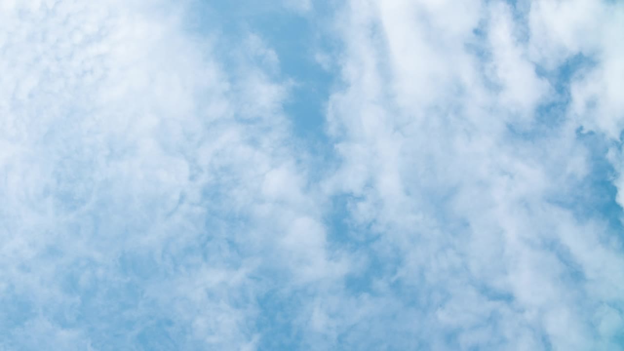 蓬松的白云在时间推移中快速移动。晴朗的天气，多云的天空背景。时间流逝的浮云在明亮的蓝天，完美的背景为您的标题文本或标识视频素材