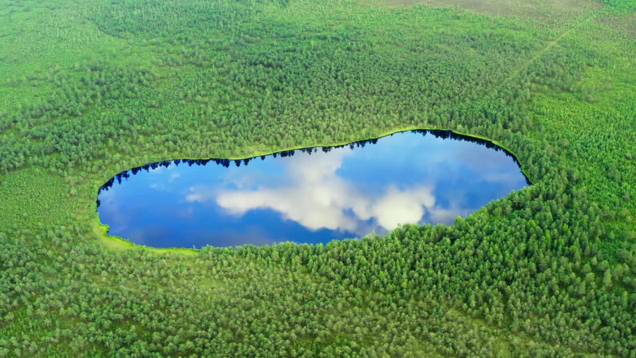 空中眼形湖，水面上有蓝天和云的倒影。原始自然，国家公园。湖面上的沼泽地区从上面看，无人机在令人难以置信的景观高空飞行视频素材