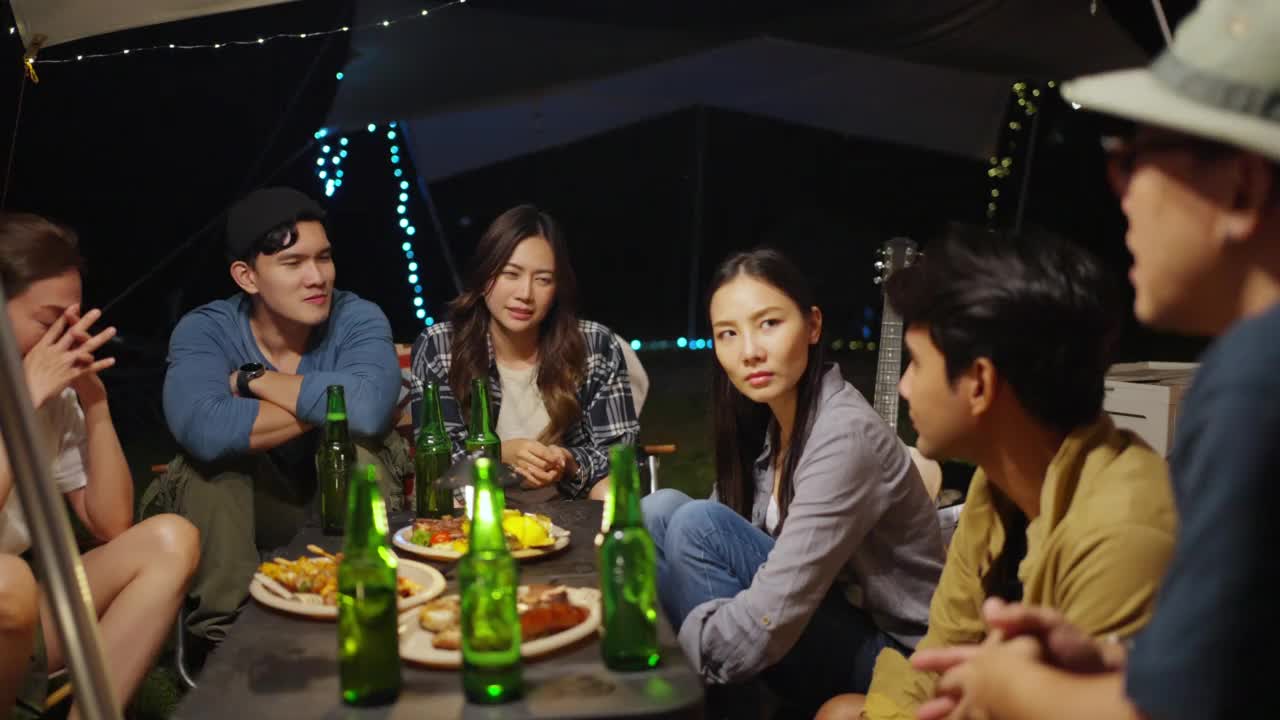 4K一群亚洲人在夏夜露营时一起做饭和吃饭。视频素材