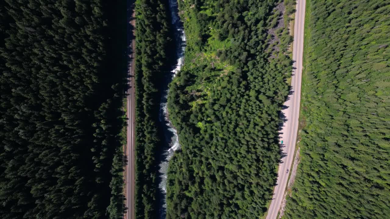 鸟瞰郁郁葱葱的山谷与铁路，河流，森林和高速公路视频素材