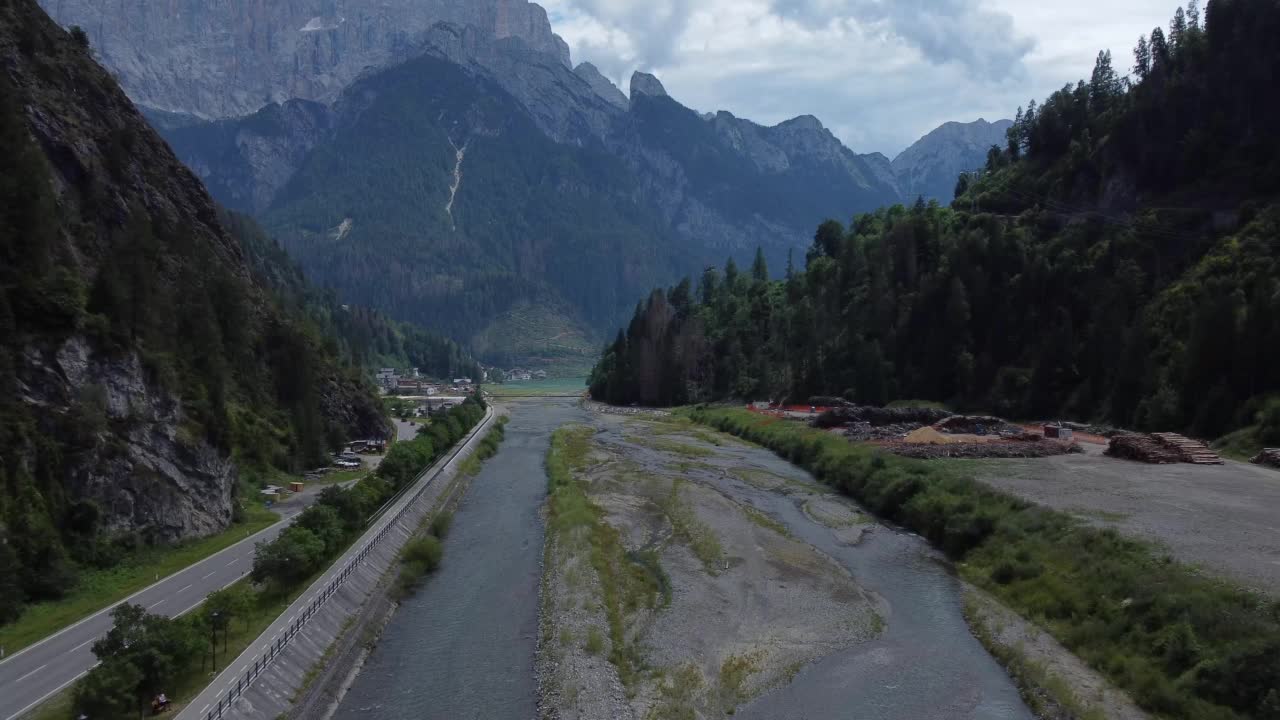 无人机拍摄的意大利Dolomites阿勒格河附近山谷中的河流，被群山环绕视频素材