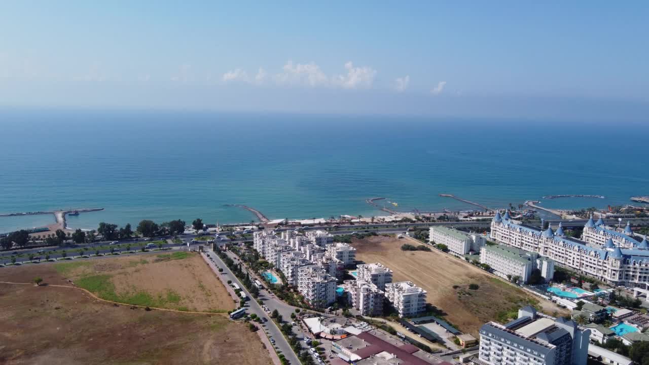 无人机拍摄的土耳其安塔利亚阿拉亚美丽的海滩度假胜地，在一个炎热的阳光灿烂的夏天，展示了土耳其沿海的海滩和水上公园。视频素材