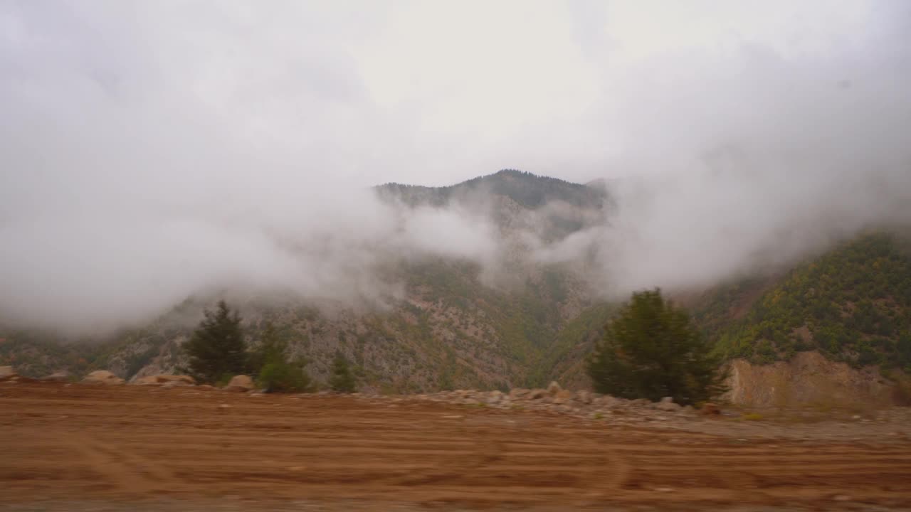 透过汽车的挡风玻璃看到的道路山和阴天。视频素材