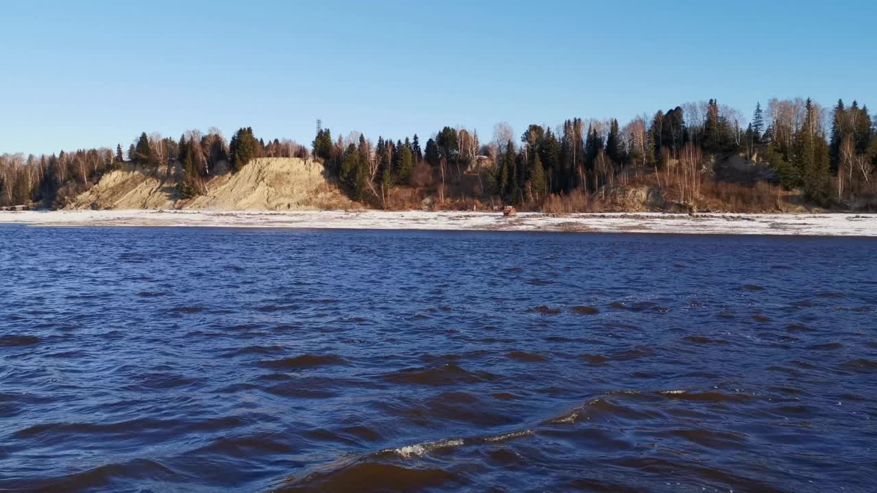 河流景观。夹。春天结冰的河流，你可以看到结冰的森林和草地，还有明亮的早晨天空。视频素材