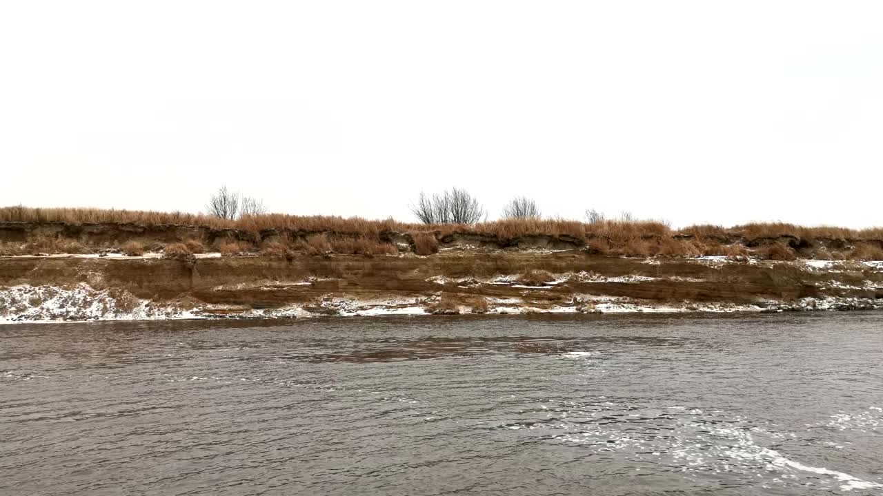 河流景观。夹。春天结冰的河流，你可以看到结冰的森林和草地，还有明亮的早晨天空。视频素材