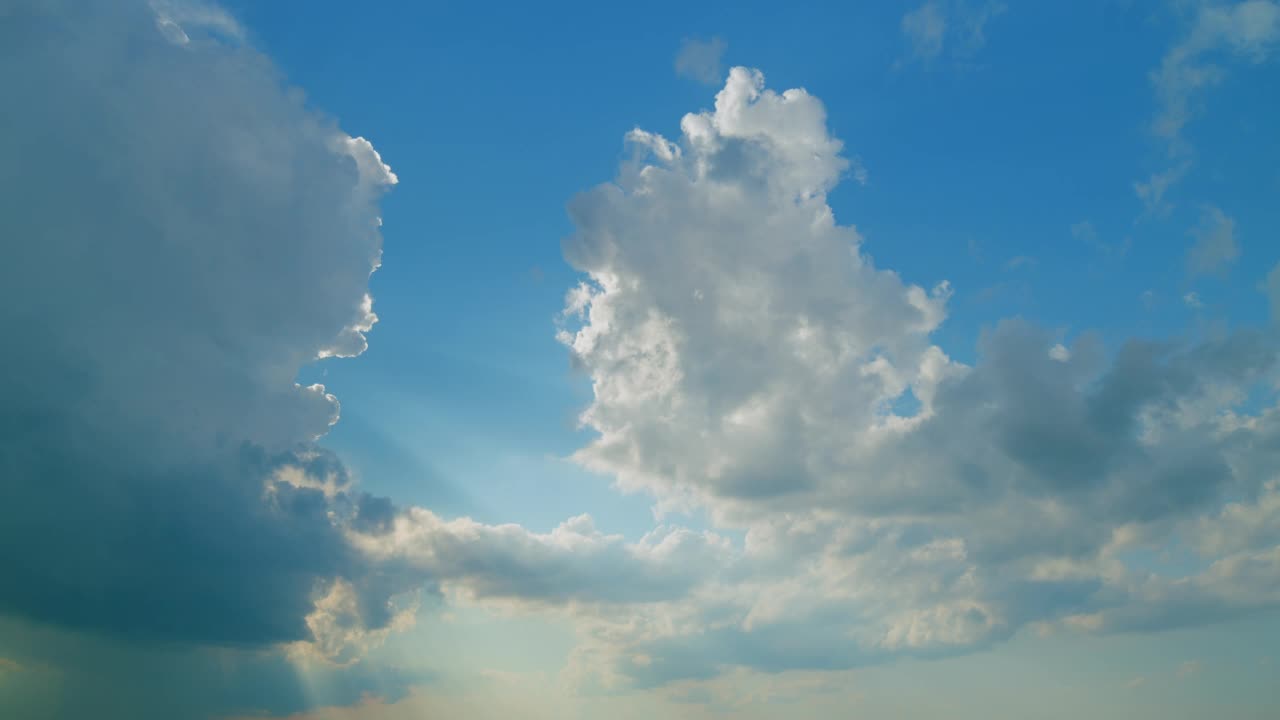 时间流逝。蓝色的天空上有白色蓬松的雨云。戏剧性的云景，令人惊叹的天空。视频素材