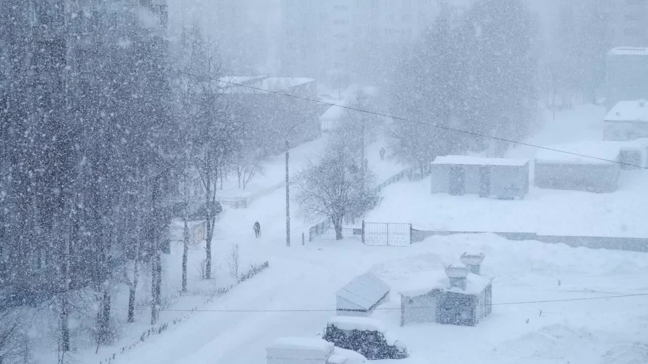 城市景观在大雪、暴风雪、暴风雪的街道上呈蓝色。视频素材