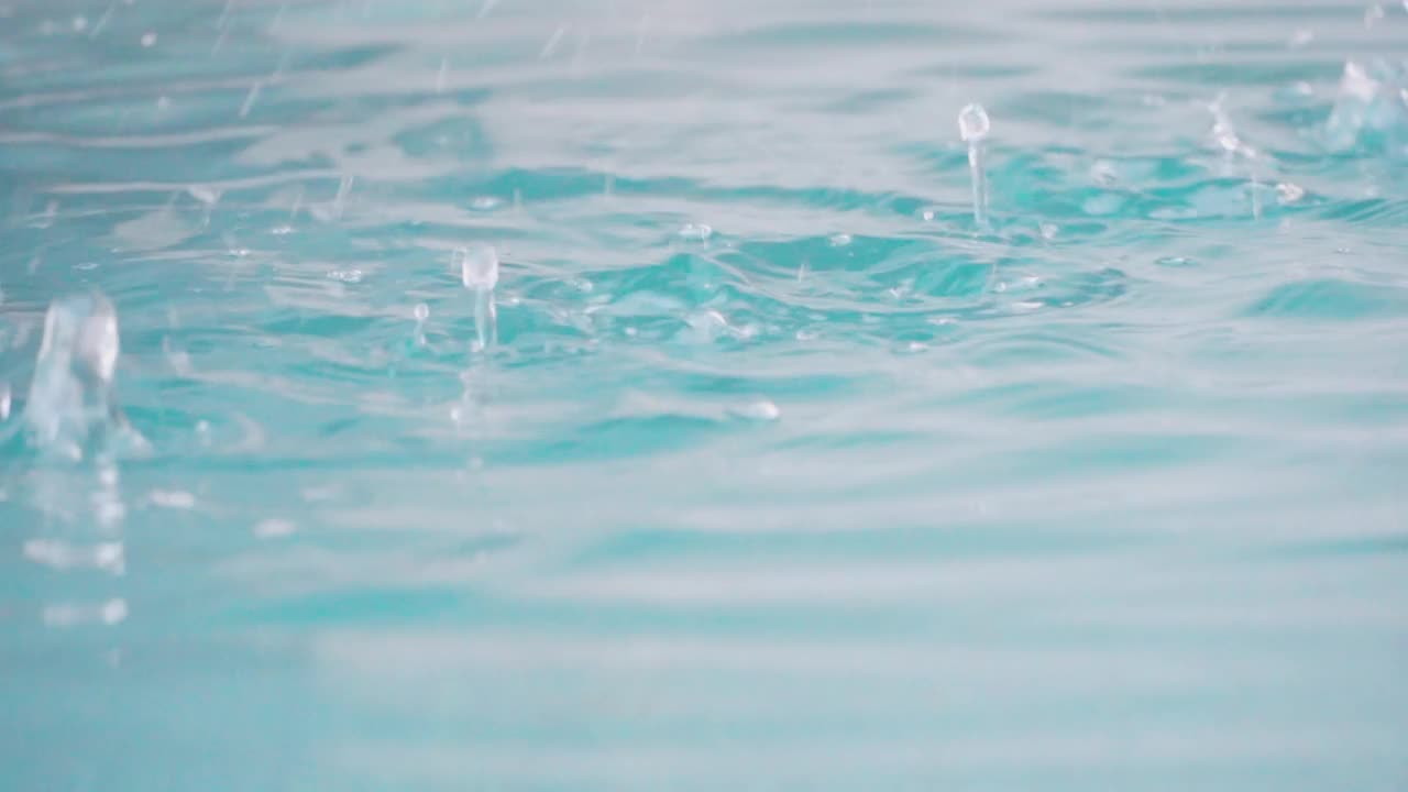 慢动作视频近距离拍摄水池中的雨滴。放松时间和自然的背景。视频素材