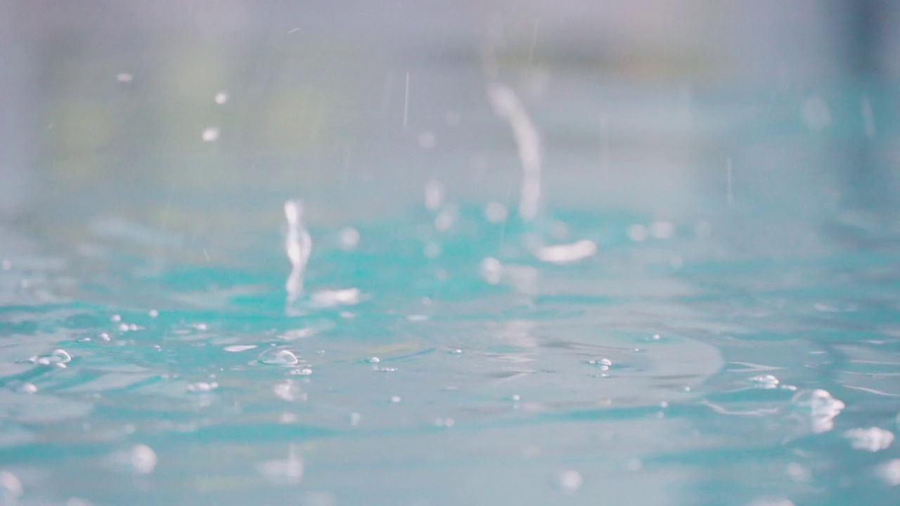 慢动作视频近距离拍摄水池中的雨滴。放松时间和自然的背景。视频素材