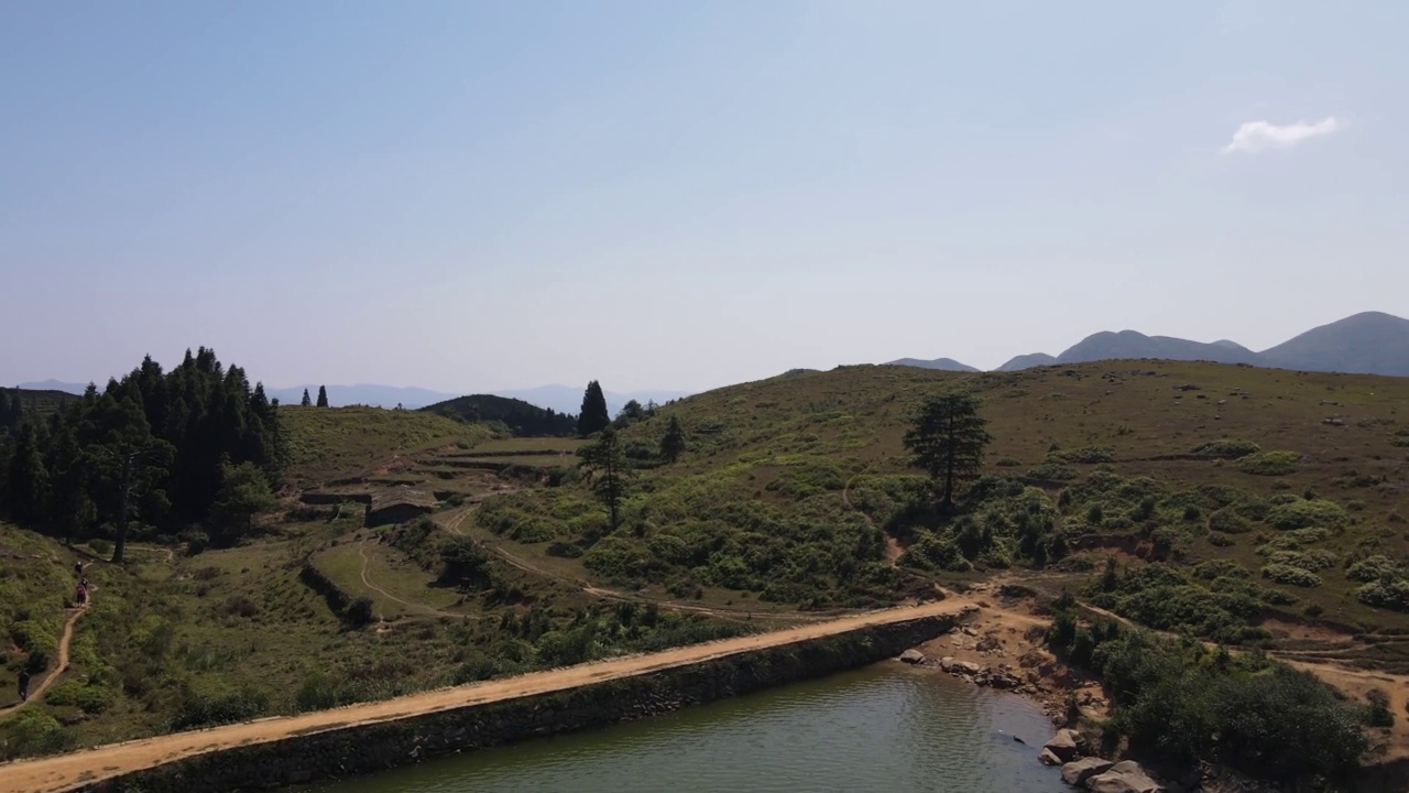 无人机穿越高山草甸上的天然湖泊视频素材