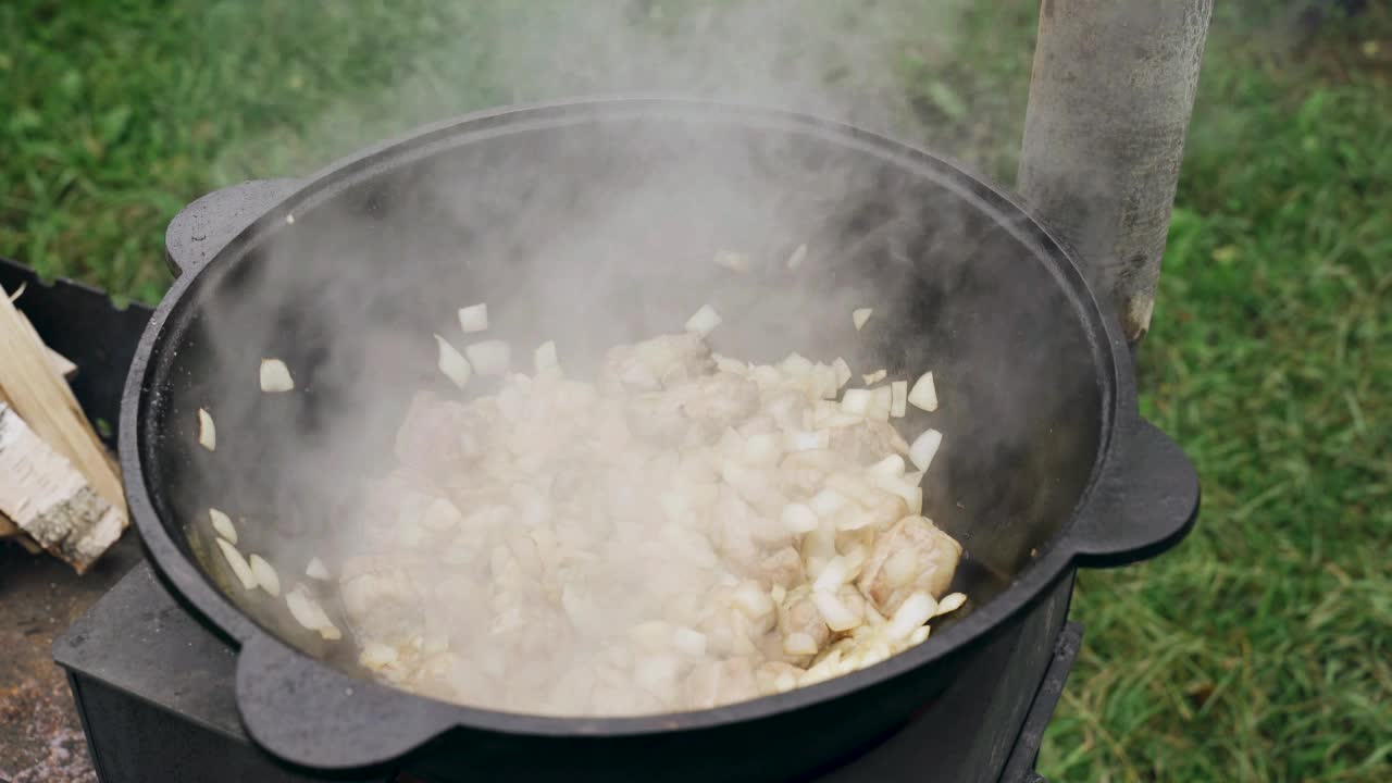 将胡萝卜倒入锅中，在锅中煎洋葱和肉，用漏勺搅拌。视频素材