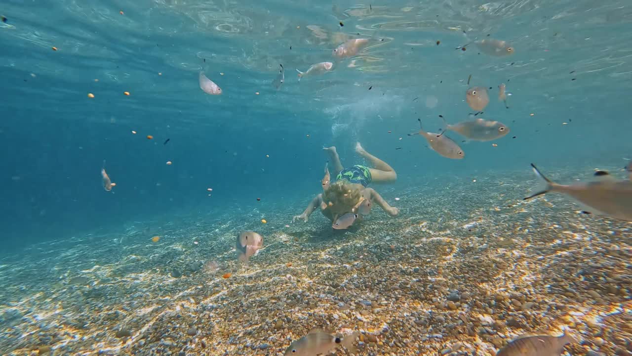 顽皮的白人孩子在水下游泳时屏住呼吸视频素材