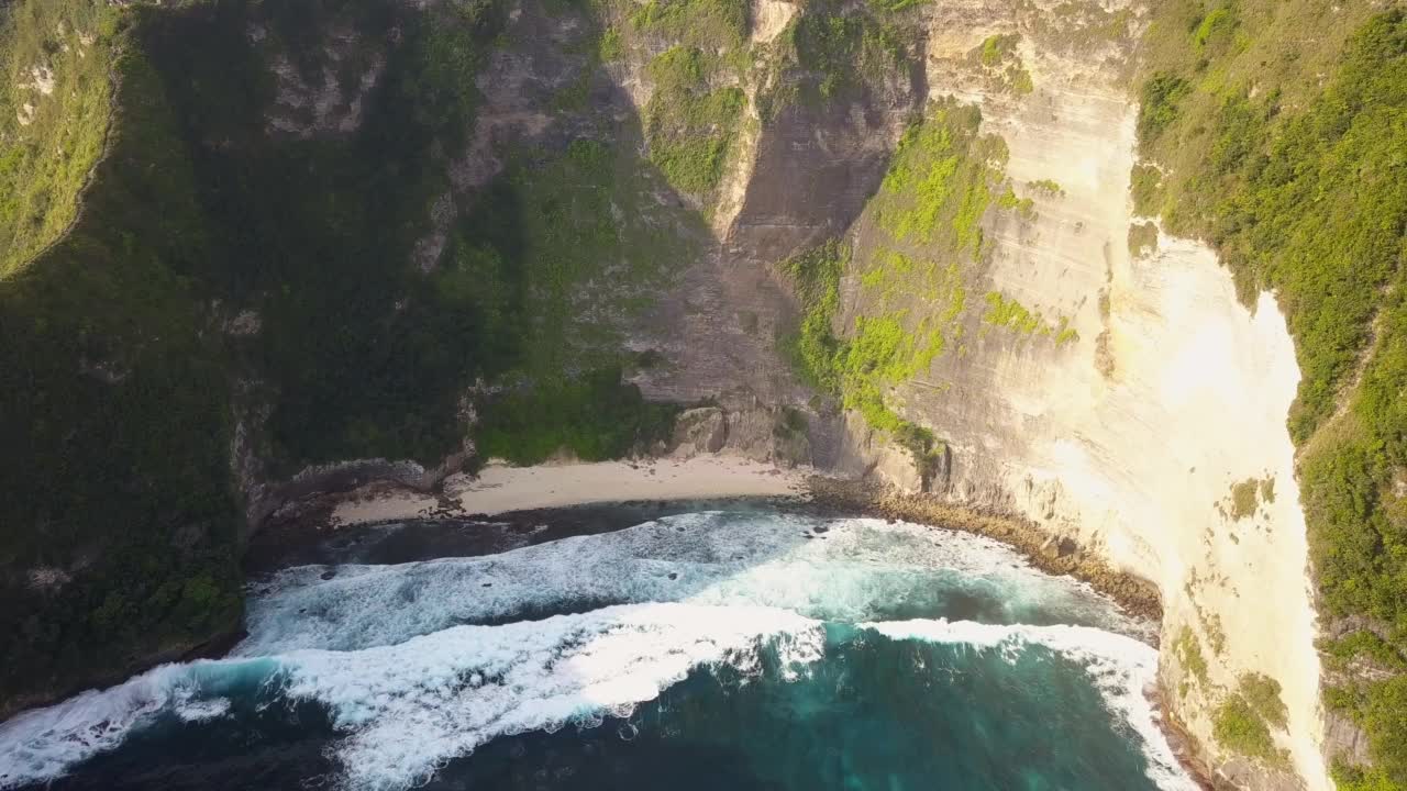 引人注目的无人机拍摄的著名的克林金海滩，又名霸王龙海滩，在印度尼西亚巴厘岛的努沙佩尼达。它以惊人的悬崖而闻名。用旋转动作拍摄。视频素材