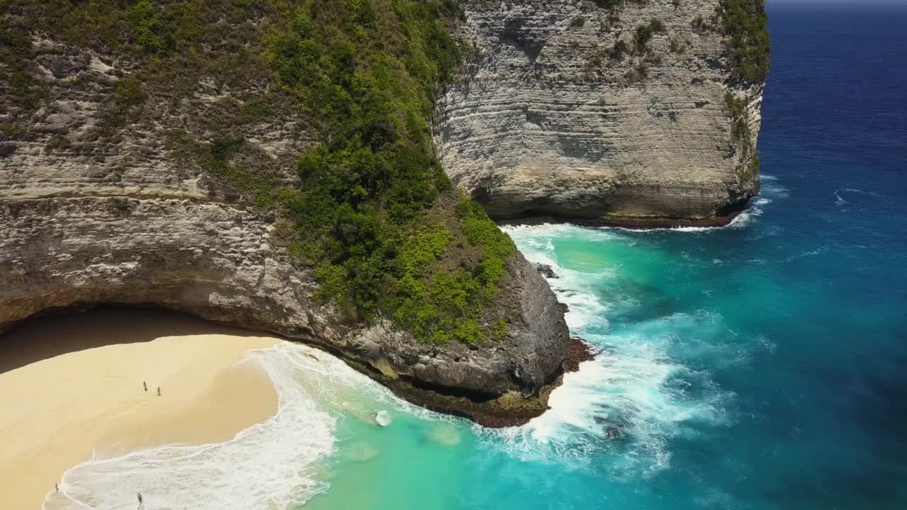 引人注目的无人机拍摄的著名的克林金海滩，又名霸王龙海滩，在印度尼西亚巴厘岛的努沙佩尼达。它以惊人的悬崖而闻名。用旋转动作拍摄。视频素材