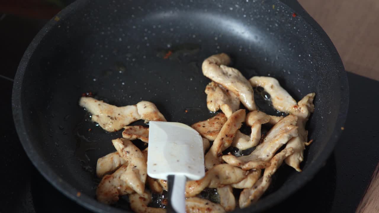 把肉块放在煎锅里煎。在煎锅中用热油煎鸡肉，特写。视频素材