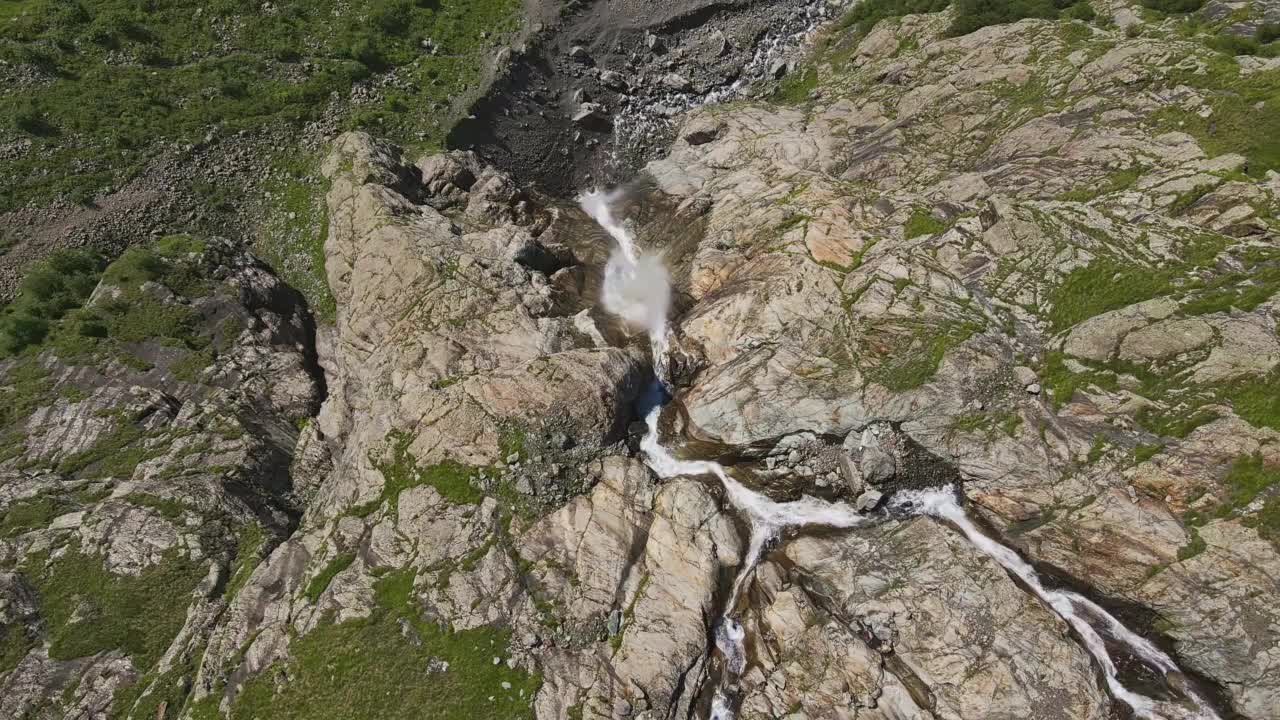 在一个阳光明媚的夏日，无人机拍摄的强大的山涧瀑布视频素材